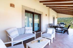 a living room with a couch and chairs and a table at Porto Cervo-Villa La Gjanda in Abbiadori