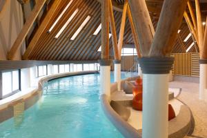 a indoor swimming pool with a water slide at Brit Hotel Du Ban in Chaudes-Aigues