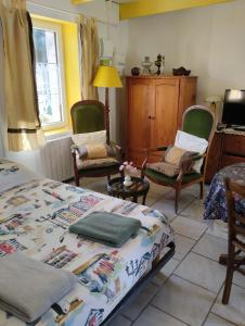 a bedroom with a bed and two chairs and a table at Ty Kozh De L'aber in Crozon