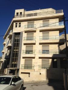a building with a car parked in front of it at Diyarkom Apartment in Amman