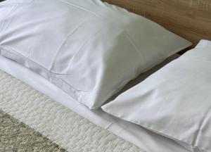 a pile of white pillows on a bed at Rezidenca Kalter Durres in Golem