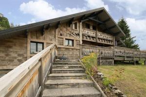 ein Holzhaus mit einer Treppe davor in der Unterkunft Les Clarines in Mouthe