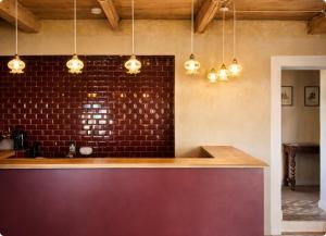 a kitchen with a bar with a brick wall at L'Hostal de Piaghja in Calenzana