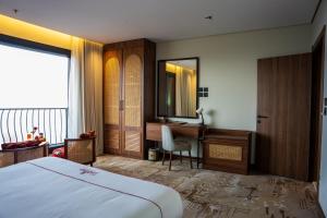 a hotel room with a bed and a desk and a mirror at فندق جولدن بلكون-Golden Balcony Hotel in Abha