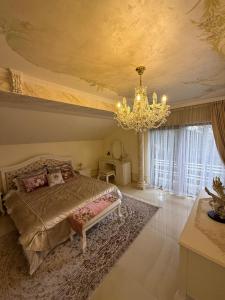 a bedroom with a large bed and a chandelier at Lily Rose villa in Karlovy Vary