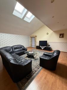 a living room with a leather couch and a table at Lily Rose villa in Karlovy Vary