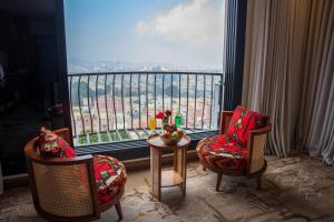 a room with two chairs and a table and a large window at فندق جولدن بلكون-Golden Balcony Hotel in Abha