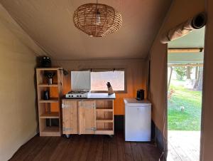 a small kitchen with a stove and a refrigerator at Glamping Les Arpents Verts in Yvoir