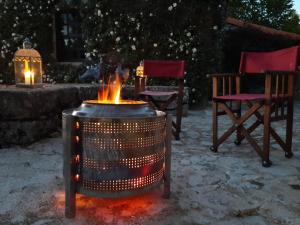 a fire pit with two chairs and two lights at Casa das Rosas in Cimbres