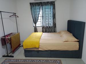 a bedroom with a large bed with a window at D'Suriah Homestay in Tanjung Karang