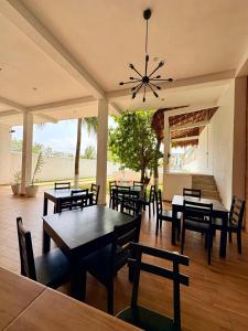 ein Esszimmer mit Tischen und Stühlen und einem Kronleuchter in der Unterkunft Jato Hotel Boutique in Tuxpan de Rodríguez Cano
