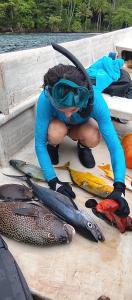 a person in a wetsuit on a boat with fish at manyaifun guest house in Minyaifuin +91 photos