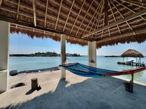 eine Hängematte am Strand unter einem Strohschirm in der Unterkunft Jato Hotel Boutique in Tuxpan de Rodríguez Cano