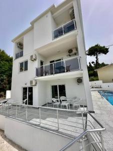 a large white building with chairs and a balcony at Dilans apartments by the sea in Bar