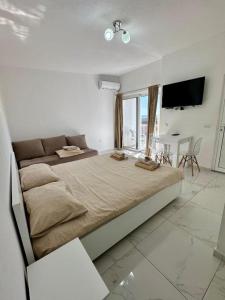 a bedroom with a large bed and a couch at Dilans apartments by the sea in Bar