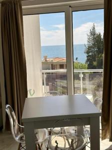 a table and chairs in front of a large window at Dilans apartments by the sea in Bar