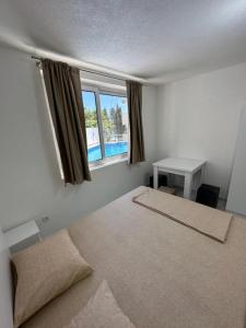 a bedroom with a bed and a desk and a window at Dilans apartments by the sea in Bar +80 photos