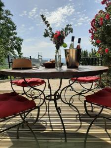 a table with wine glasses and flowers on a patio at Casa das Rosas in Cimbres