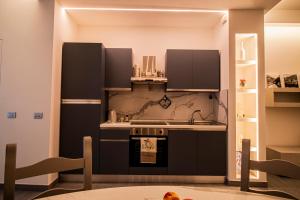 a kitchen with a black refrigerator and a sink at Casa Peppina in Gubbio