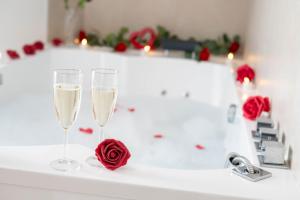 two glasses of champagne and a rose on a bathtub at Grand Appartement 2 chambres et 2 SDB, Balnéo, Centre-ville in Quimper +44 photos