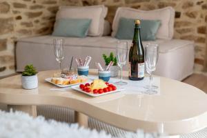 a table with a bottle of wine and wine glasses at Grand Appartement 2 chambres et 2 SDB, Balnéo, Centre-ville in Quimper