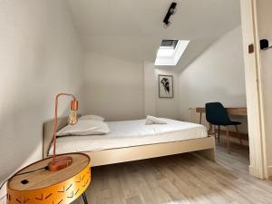 a bedroom with a bed with a lamp and a desk at Maison Duplex Collection, in Limoges