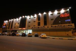 ein Gebäude mit nachts auf einem Parkplatz geparkt in der Unterkunft Raoum Inn Majmaa in Al Majma'ah