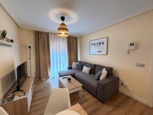 a living room with a couch and a tv at Apartamento Cueto II in Soto del Barco