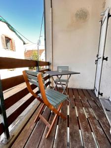 a table and a chair sitting on a deck at Maison Duplex Collection, in Limoges