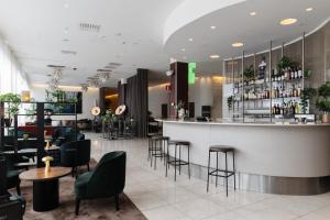 a bar in a restaurant with chairs and tables at Clarion Hotel Arlanda Airport Terminal in Arlanda