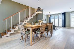 a dining room with a wooden table and chairs at FeHa Windspiel in Loddin +21 photos