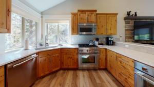 a kitchen with wooden cabinets and stainless steel appliances at 1 Fifteenth Tee Lane in Sunriver
