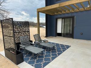 two chairs sitting on a patio next to a house at The Sandpearl in Stevensville