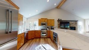 a large kitchen with wooden cabinets and stainless steel appliances at 1 Fifteenth Tee Lane in Sunriver