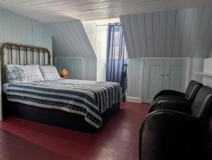 a bedroom with a bed and a couch at Auberge Les Blancs Moutons in Saint-Laurent-de-l'ile d'Orleans