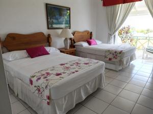 a bedroom with two beds and a balcony at Villa Nirvana II in Mount Irvine +29 photos