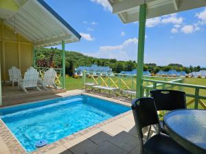 a swimming pool with a table and chairs and a patio at Villa Nirvana II in Mount Irvine
