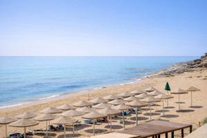 a bunch of umbrellas and chairs on a beach at B&B Capo Rizzuto Armenes in Capo Rizzuto +44 photos