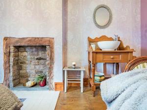 a bedroom with a sink and a stone fireplace at 4 Bed in Wigton oc-sz384 in Bothel