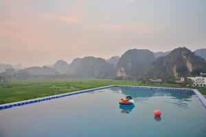 a person on a raft in a body of water at Tam Coc Sunshine Villa in Vũ Lâm