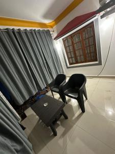 a living room with two chairs and a table at Vinayak guest house in Mandrem