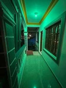 a hallway with green lighting in a house at Vinayak guest house in Mandrem
