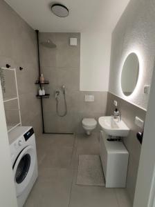 a bathroom with a washing machine and a sink at Bauna Suites & Apartments in Baunatal