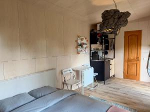 a bedroom with a bed and a table and a kitchen at D a c h a in Ventspils