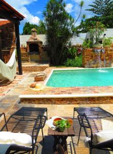 a swimming pool with chairs and a table next to it at Casa Magu Merida in Mérida
