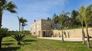 a brick house with palm trees in front of it at Antica dimora "Nicole e Cristiano" in Otranto