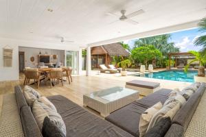 an open living room with a couch and a pool at Clos du Littoral by Sealodge Mauritius in Grand-Baie