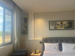 a hotel room with a bed and a window at Grand Vachellia Karatu in Karatu