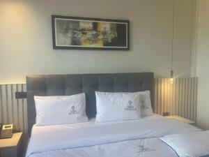 a bedroom with a bed with white sheets and pillows at Grand Vachellia Karatu in Karatu
