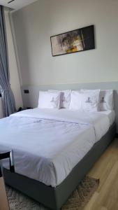 a bed with white sheets and pillows in a bedroom at Grand Vachellia Karatu in Karatu